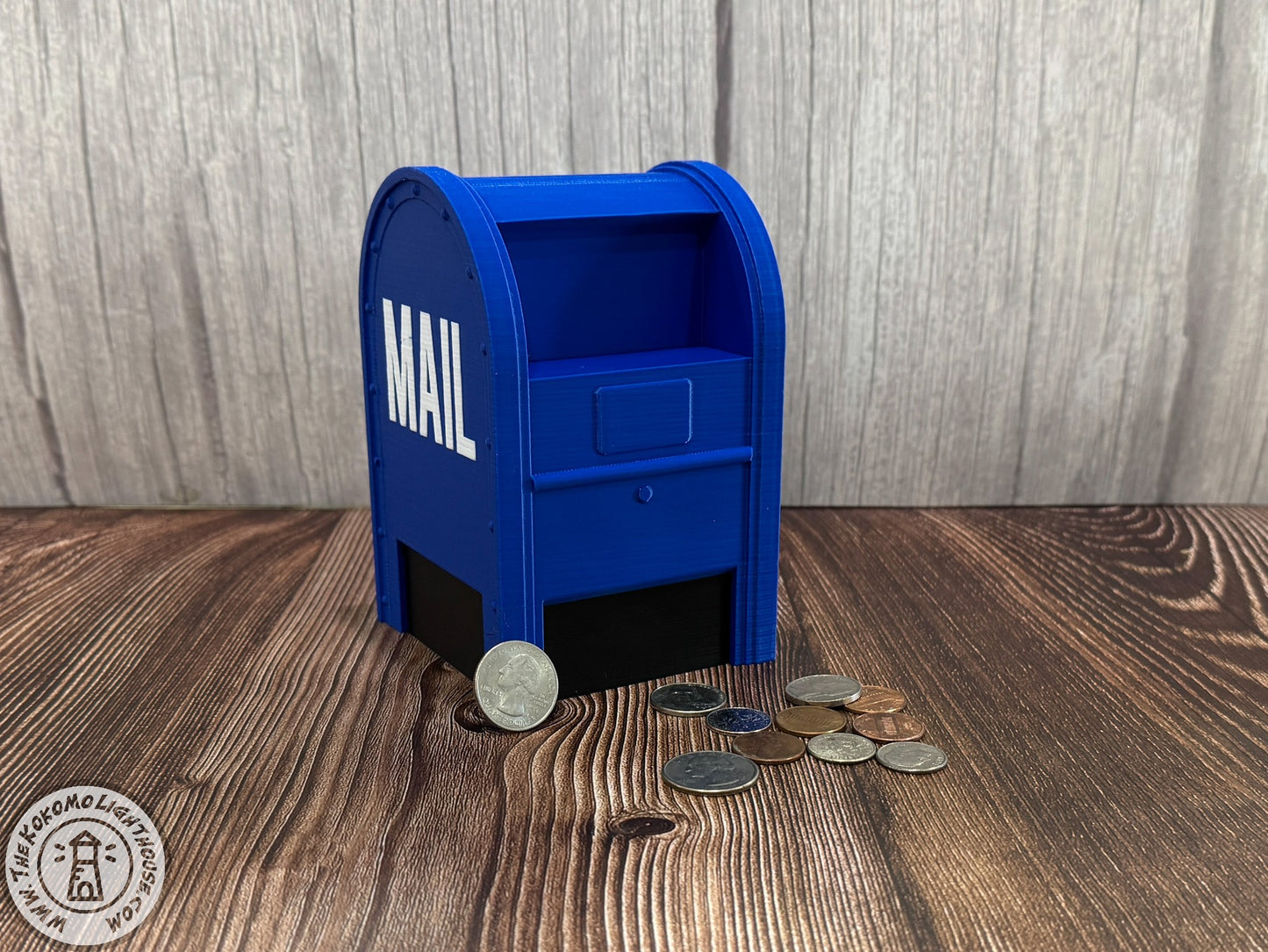 Blue mailbox-shaped piggy bank with coins on a wooden surface