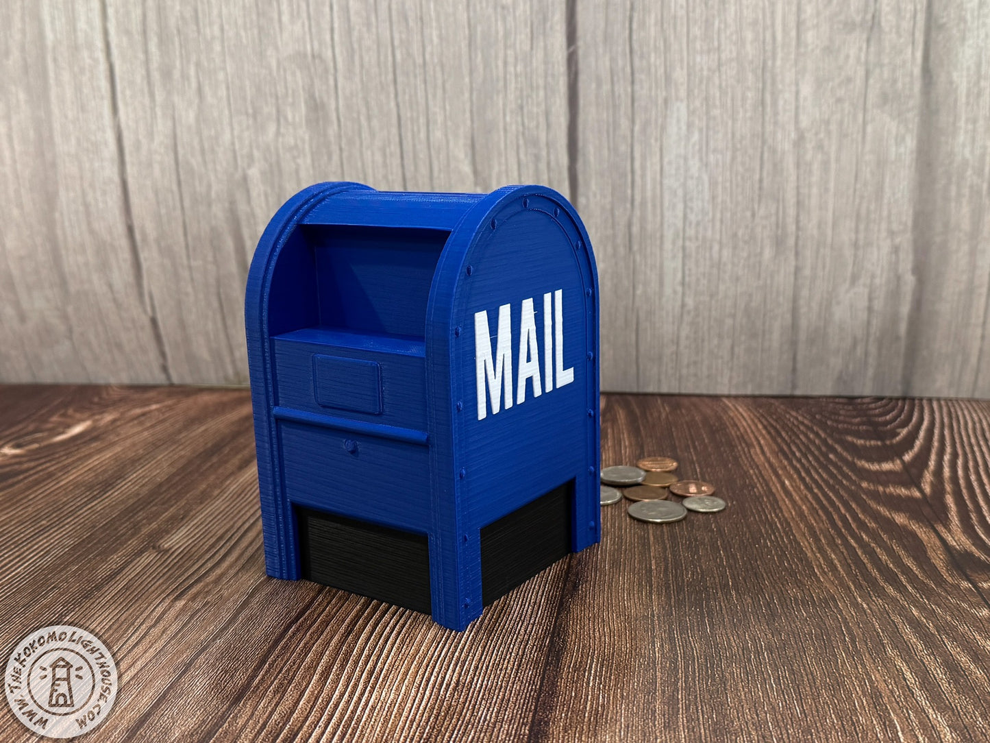 Blue mailbox-shaped piggy bank with 'MAIL' on a wooden surface