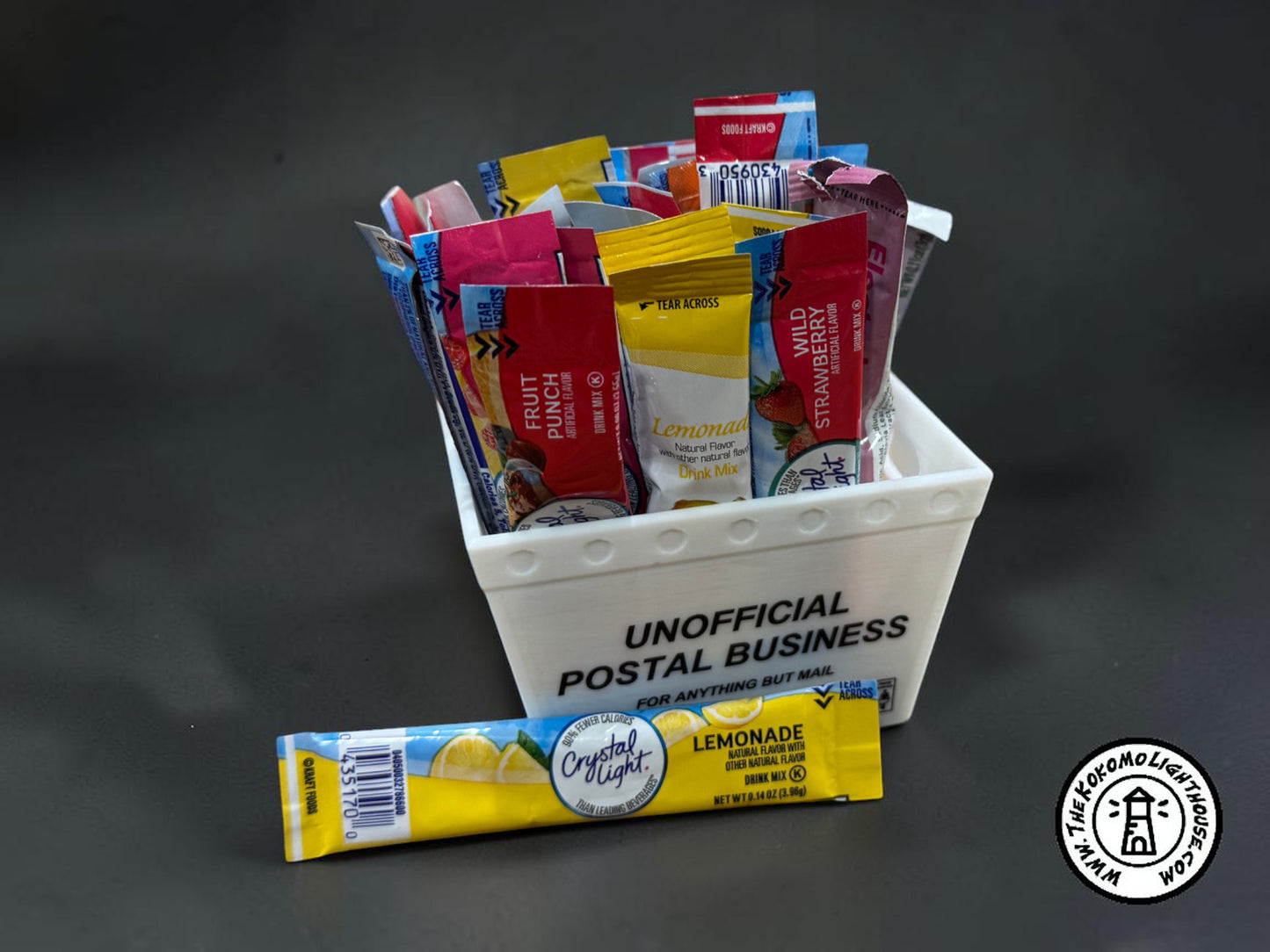 A mini postal tray filled with drink packets with one in front on a dark background