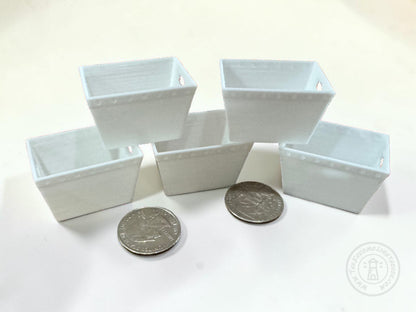 Five miniature white dollhouse postal tubs arranged on a white surface, with two quarters placed in front for scale.
