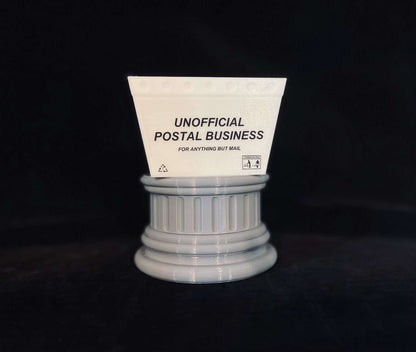 A mini mail tub with an "Unofficial Postal Business" label on a gray pedestal