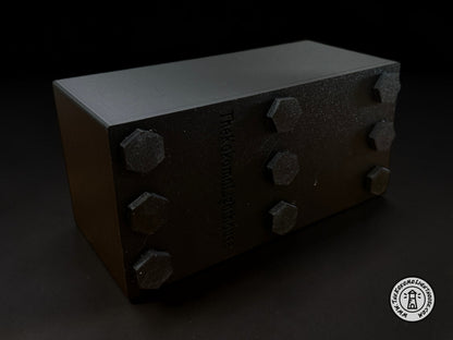 The bottom view of a caddy highlighting the nine magnets on the bottom on a dark 
colored background.
