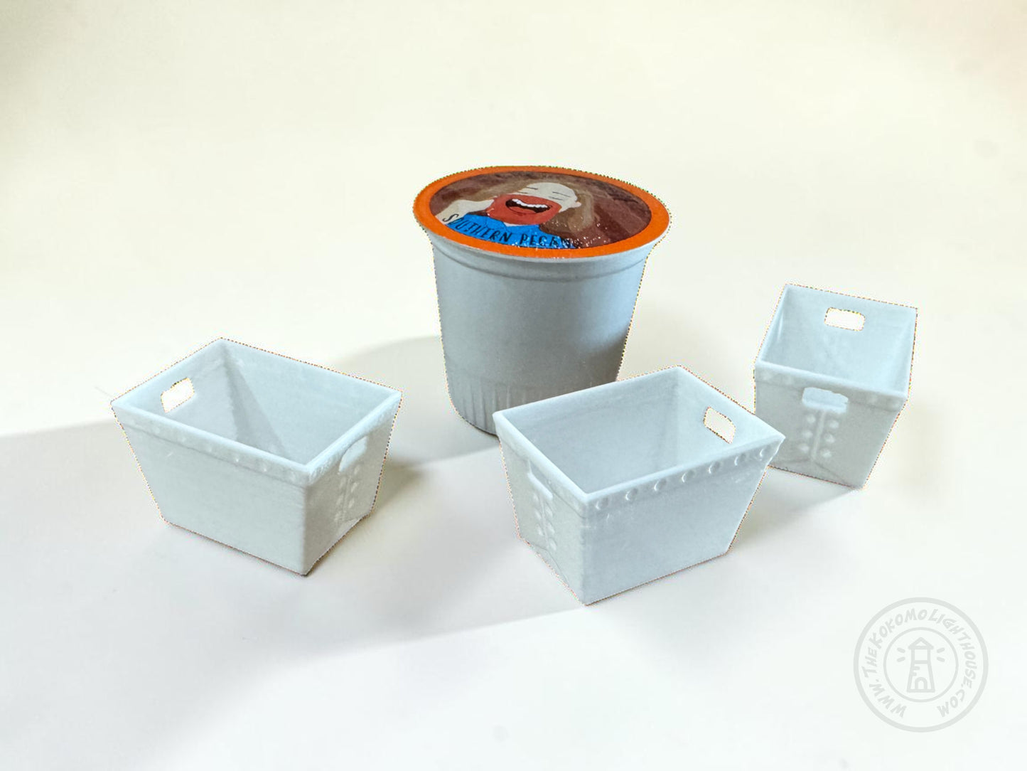 3 dollhouse scale dps tubs on a light background with a k cup coffe pod for size comparison