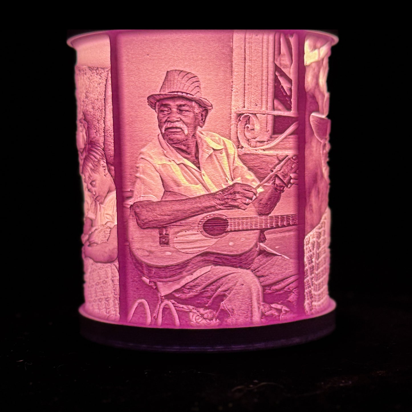Lit custom photo lamp showing a man playing guitar, with the portrait glowing through the cylindrical lithophane shade.