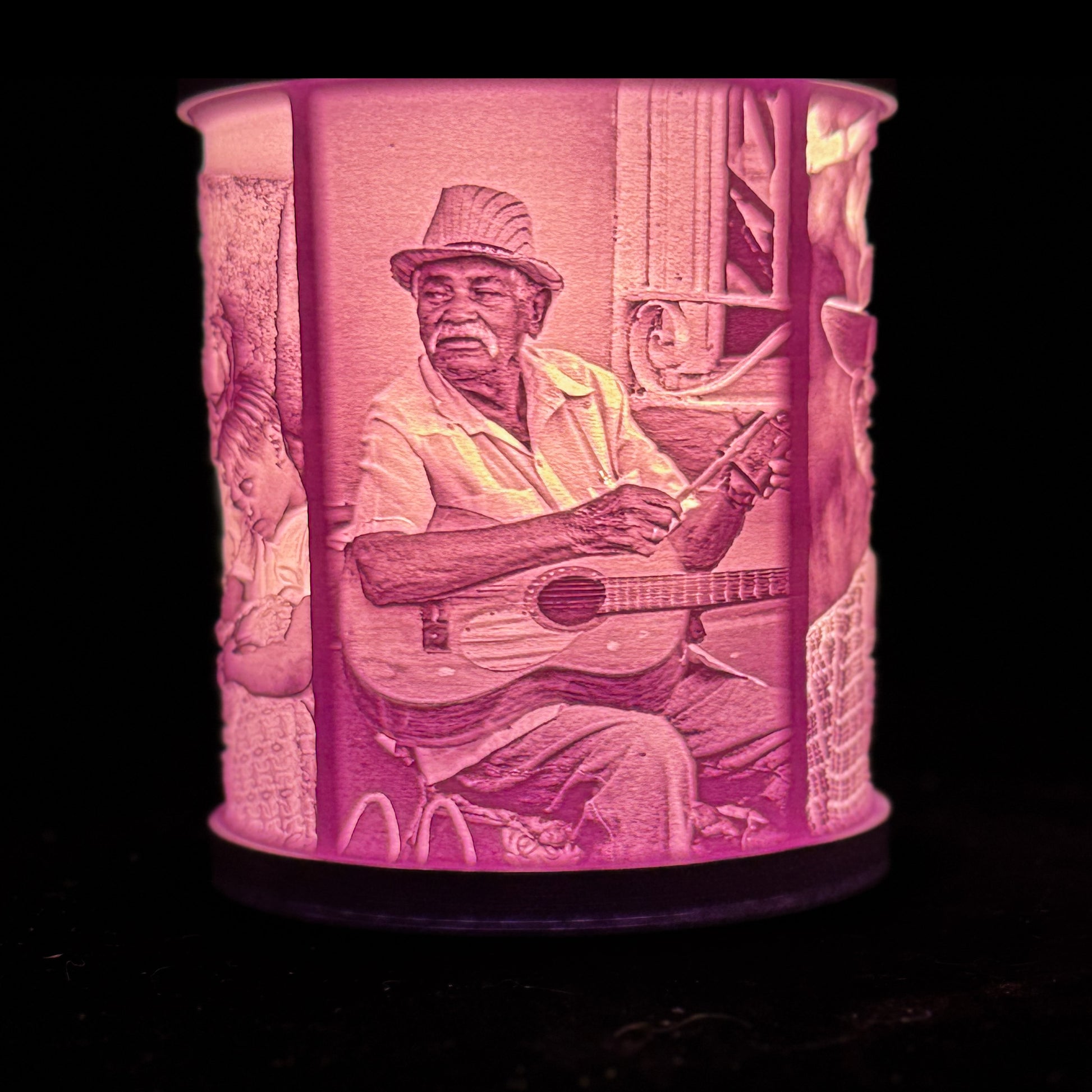 Lit custom photo lamp showing a man playing guitar, with the portrait glowing through the cylindrical lithophane shade.