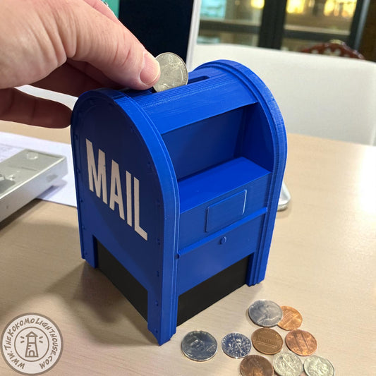 Blue mailbox-shaped piggy bank with coins around it on a table.