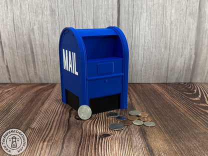Blue mailbox-shaped piggy bank with coins on a wooden surface
