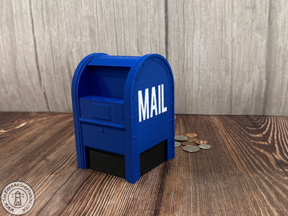 Blue mailbox-shaped piggy bank with 'MAIL' on a wooden surface