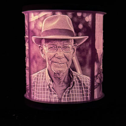 Lit memorial lithophane lamp showing an older man wearing glasses and a hat, with the portrait glowing through the white shade.