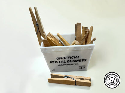 A mini postal tub filled with clothespins on a light background