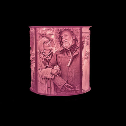 Lit personalized lithophane lamp showing an older couple walking together in winter jackets, with detailed photo texture visible in the glowing shade.