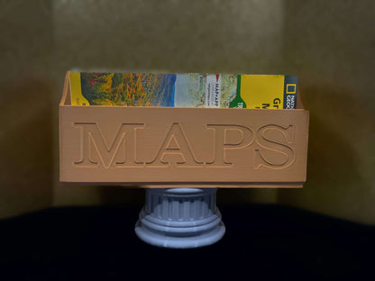 Tan NatGeo Map Box holding maps on a gray pedestal