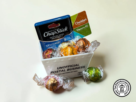 a mini mail tub filled with small candies, a gift card, and a chap stick