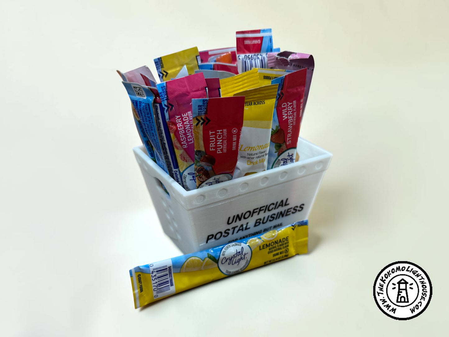 A mini postal tray filled with drink packets with one in front on a light background