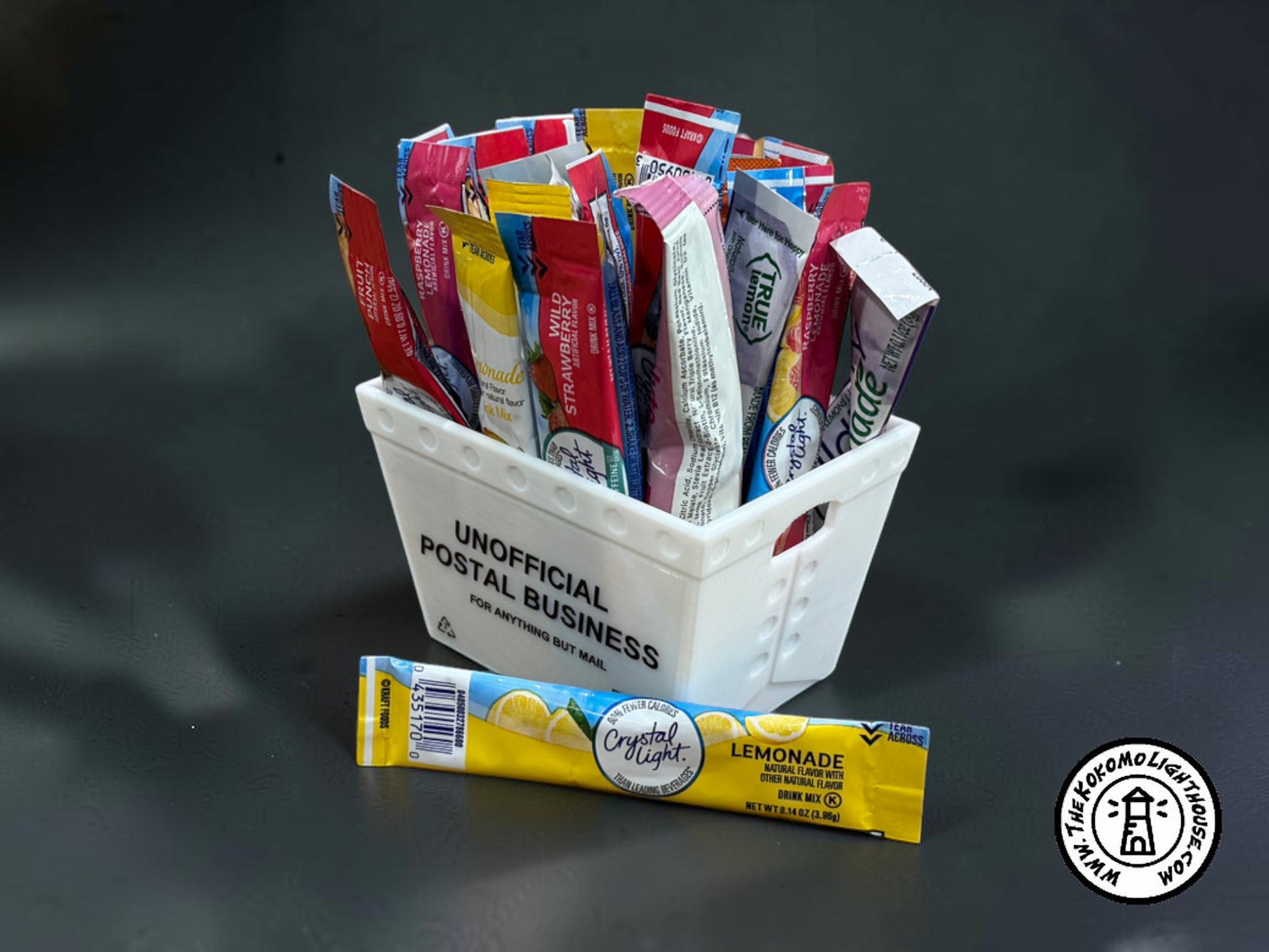 A mini postal tray filled with drink packets with one in front on a dark background