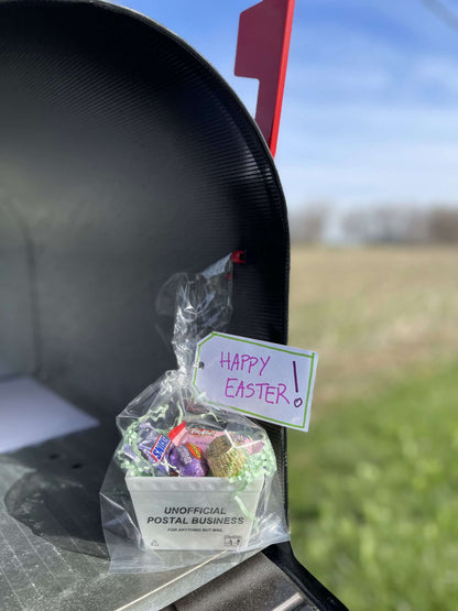 A gift basket made from a mini postal tub filled with easter candy and with a Happy Easter note
